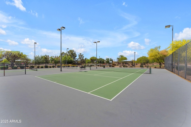 view of tennis court featuring fence