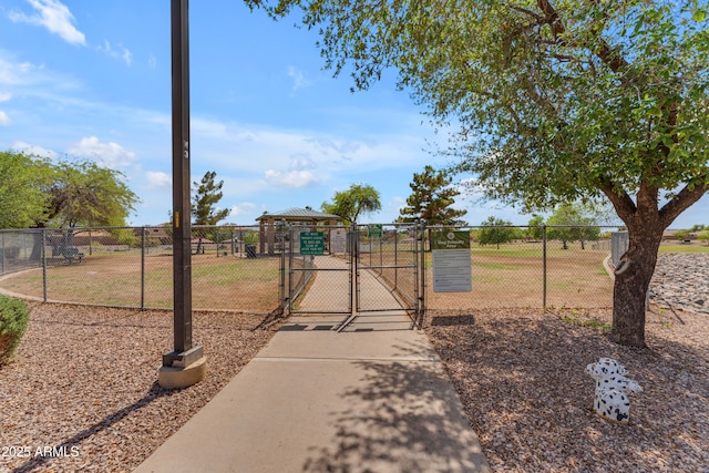 view of jungle gym featuring fence and a gate
