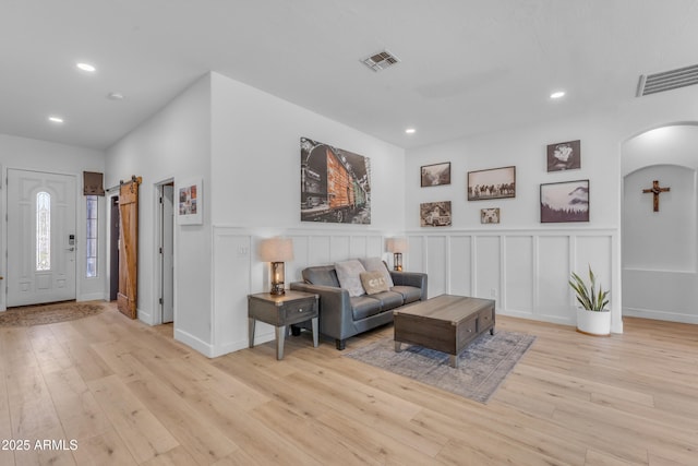 living area with recessed lighting, arched walkways, and visible vents