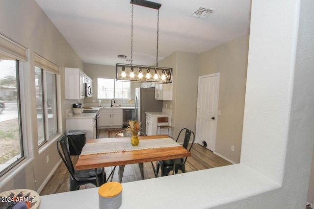 dining space featuring wood-type flooring and sink