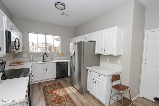 kitchen featuring light hardwood / wood-style floors, black dishwasher, electric range, white cabinets, and sink