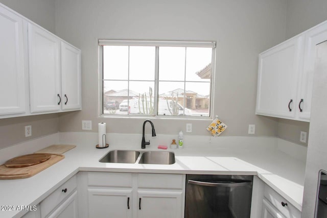 kitchen with stainless steel dishwasher, white cabinets, and sink