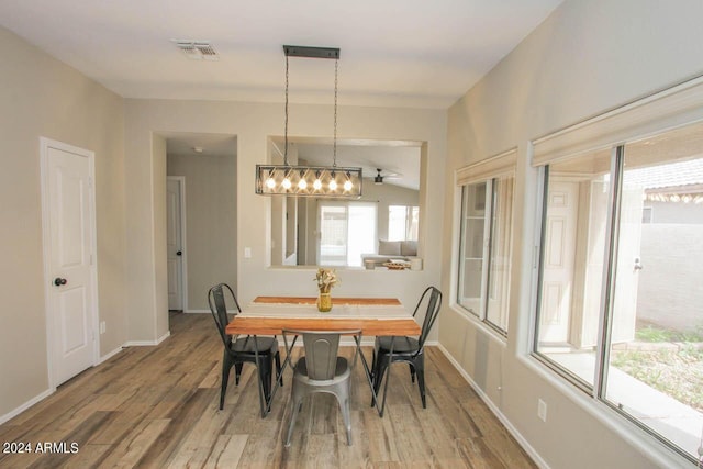 dining space with ceiling fan, lofted ceiling, and hardwood / wood-style flooring