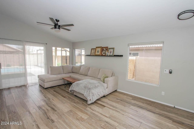 living room with ceiling fan, light hardwood / wood-style flooring, and lofted ceiling