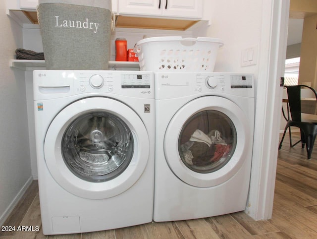 washroom featuring washing machine and dryer and hardwood / wood-style flooring