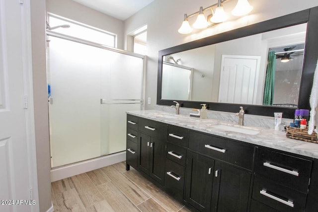 bathroom with vanity, ceiling fan, and a shower with door