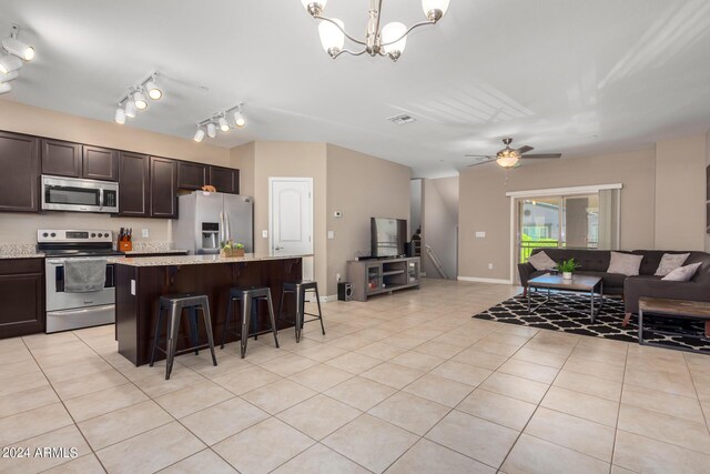 kitchen with light tile patterned floors, an inviting chandelier, sink, and light stone countertops