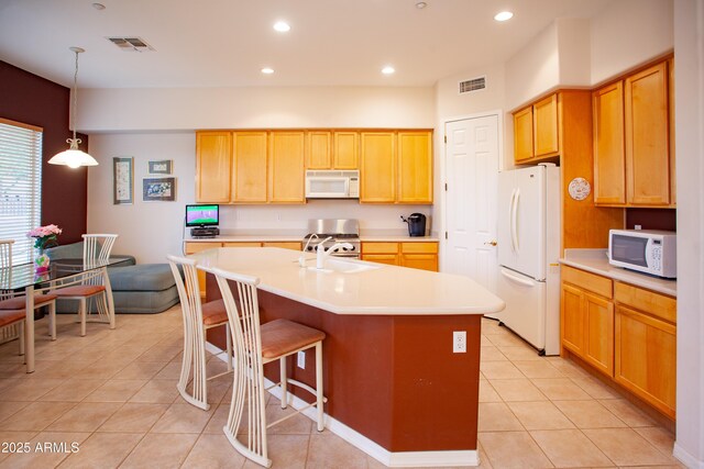 7413 E Russet Sky Dr, Scottsdale, AZ 85266 - kitchen with white appliances, light tile patterned floors, a center island with sink, light countertops, and a breakfast bar area