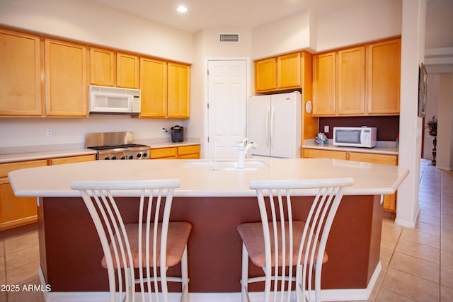 7413 E Russet Sky Dr, Scottsdale, AZ 85266 - kitchen with white appliances, a sink, an island with sink, light tile patterned floors, and light countertops