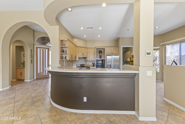 kitchen with stainless steel fridge with ice dispenser, light tile patterned flooring, sink, and light brown cabinets