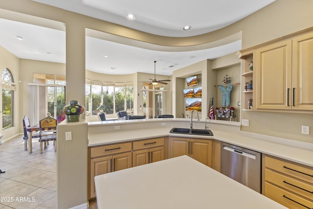 kitchen featuring light brown cabinetry, sink, stainless steel dishwasher, and kitchen peninsula