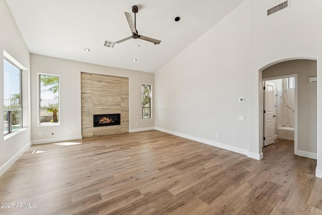 11008 N 119th Pl, Scottsdale, AZ 85259 - unfurnished living room with ceiling fan, arched walkways, plenty of natural light, light wood-style floors, and high vaulted ceiling