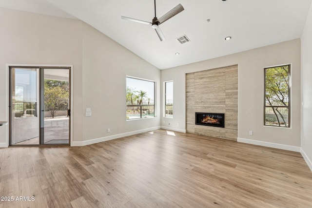 11008 N 119th Pl, Scottsdale, AZ 85259 - unfurnished living room with plenty of natural light, high vaulted ceiling, light wood-style flooring, and a tiled fireplace