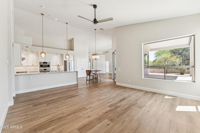 11008 N 119th Pl, Scottsdale, AZ 85259 - unfurnished living room with light wood-style floors, a ceiling fan, and high vaulted ceiling