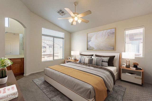 carpeted bedroom featuring ceiling fan, ensuite bath, and lofted ceiling