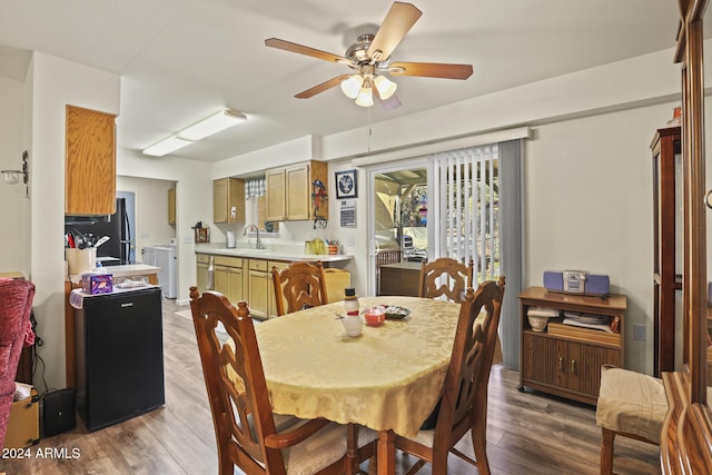 dining area featuring separate washer and dryer, ceiling fan, sink, and hardwood / wood-style flooring