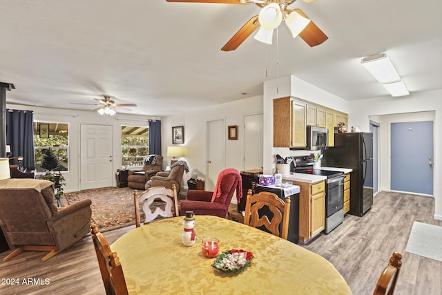 dining space featuring ceiling fan and light wood-type flooring