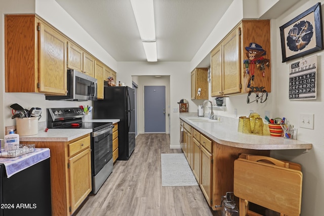 kitchen featuring kitchen peninsula, sink, appliances with stainless steel finishes, and light hardwood / wood-style flooring