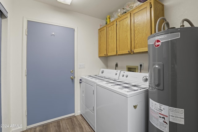 washroom with cabinets, electric water heater, dark wood-type flooring, and washing machine and dryer