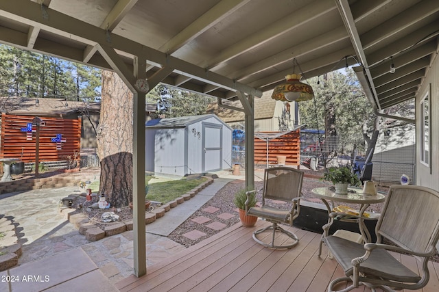 wooden terrace featuring a storage shed and a patio