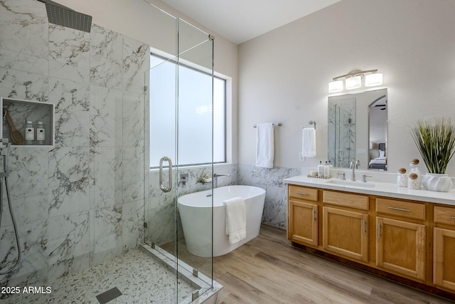 bathroom featuring vanity, hardwood / wood-style flooring, tile walls, and separate shower and tub