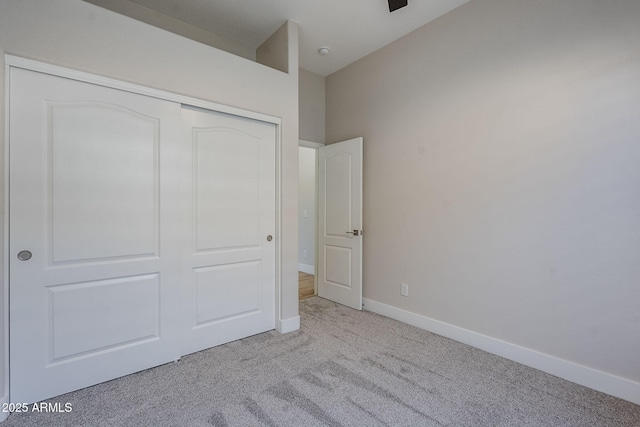 unfurnished bedroom featuring light colored carpet and a closet