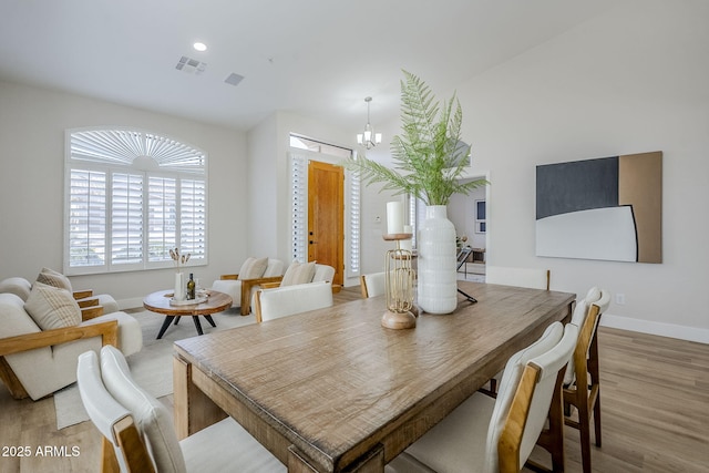 dining space with a chandelier and light wood-type flooring