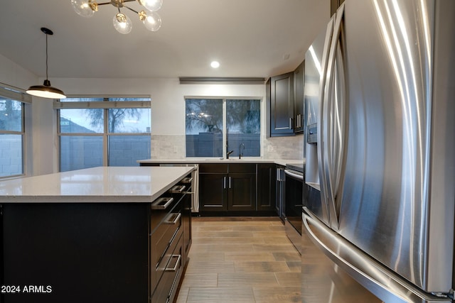 2203 E Crest Ln, Phoenix, AZ 85024 - kitchen featuring appliances with stainless steel finishes, backsplash, a chandelier, light stone counters, and recessed lighting