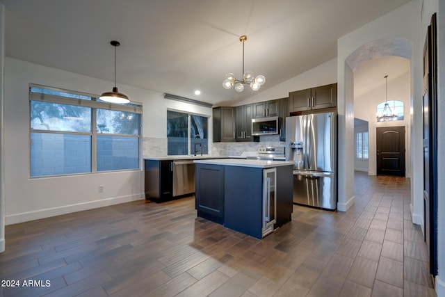 2203 E Crest Ln, Phoenix, AZ 85024 - kitchen with appliances with stainless steel finishes, a chandelier, light countertops, backsplash, and dark wood finished floors