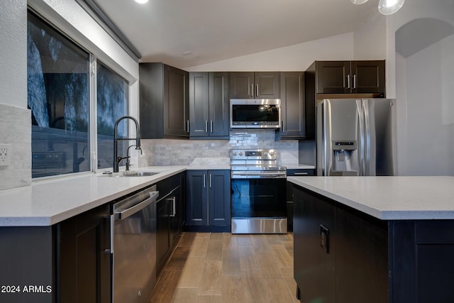 2203 E Crest Ln, Phoenix, AZ 85024 - kitchen featuring appliances with stainless steel finishes, tasteful backsplash, lofted ceiling, and light wood-type flooring