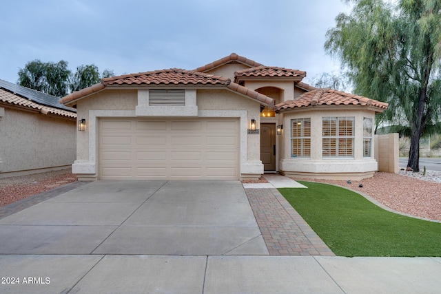 2203 E Crest Ln, Phoenix, AZ 85024 - mediterranean / spanish-style home with concrete driveway, a garage, stucco siding, and a tile roof