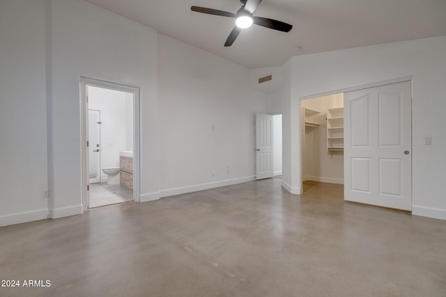2203 E Crest Ln, Phoenix, AZ 85024 - unfurnished bedroom with a walk in closet, finished concrete flooring, a closet, connected bathroom, and ceiling fan