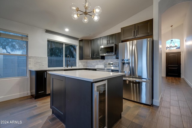2203 E Crest Ln, Phoenix, AZ 85024 - kitchen with appliances with stainless steel finishes, a chandelier, wine cooler, lofted ceiling, and backsplash