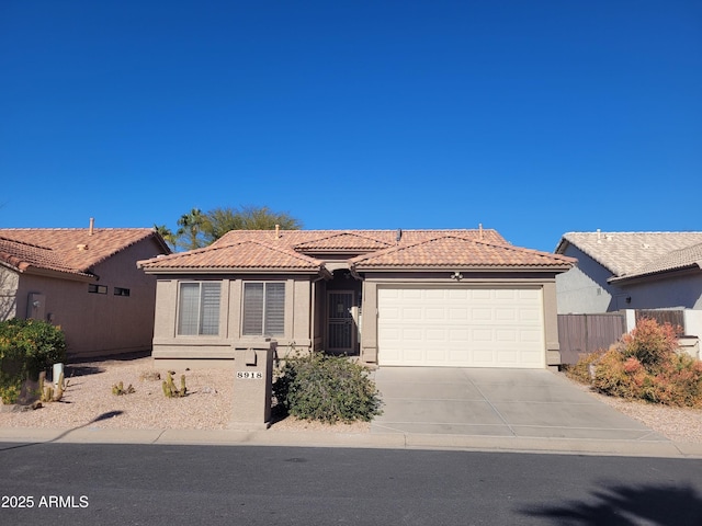 view of front of property with stucco siding, concrete driveway, an attached garage, and a tiled roof