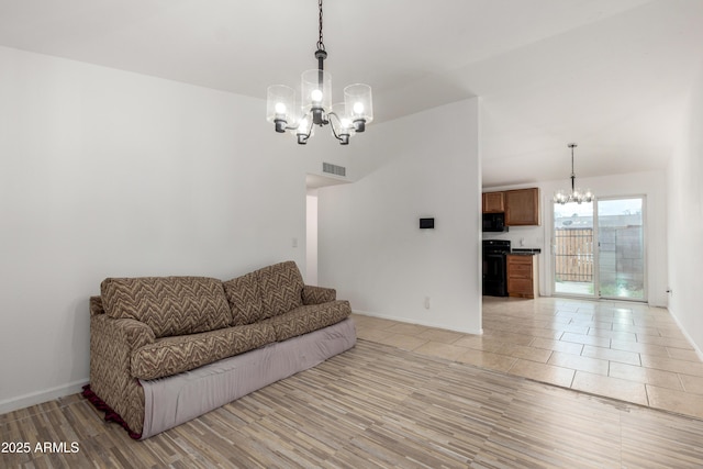 living room featuring light wood finished floors, an inviting chandelier, visible vents, and baseboards