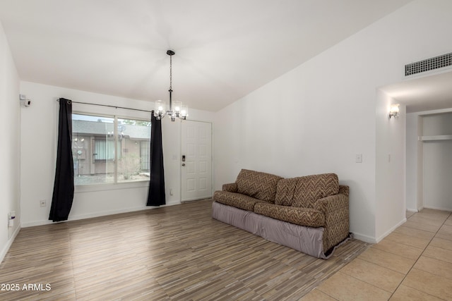 living area with a chandelier, light wood-style floors, visible vents, and baseboards