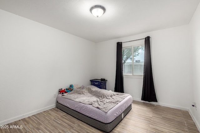 bedroom featuring baseboards and light wood-style floors