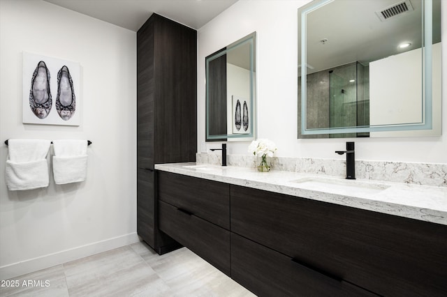 full bathroom featuring visible vents, a sink, baseboards, and a shower with shower door