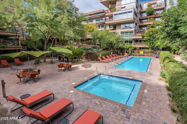community pool with a community hot tub and a patio area