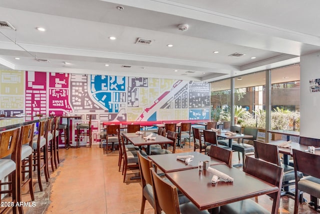 dining area featuring concrete flooring, a tray ceiling, and visible vents