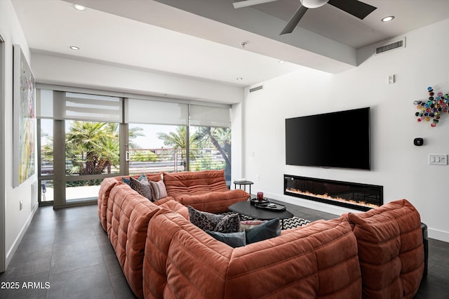 living room with a ceiling fan, visible vents, baseboards, a glass covered fireplace, and recessed lighting