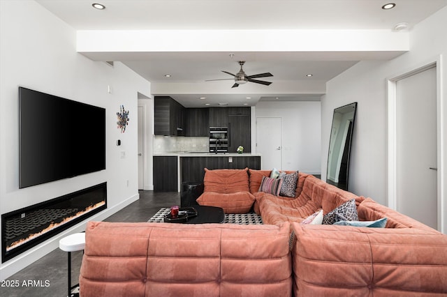 living room with baseboards, a ceiling fan, and recessed lighting