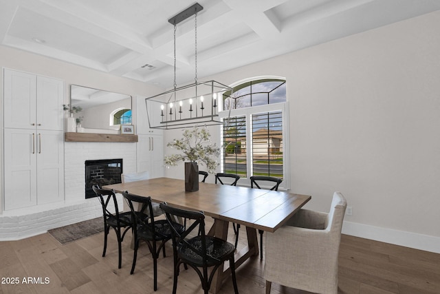 3173 E Page Ave, Gilbert, AZ 85234 - dining area featuring baseboards, a brick fireplace, beam ceiling, coffered ceiling, and wood finished floors