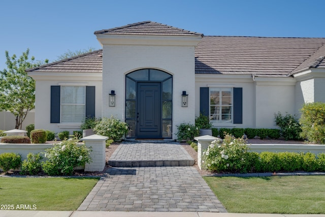 3173 E Page Ave, Gilbert, AZ 85234 - doorway to property featuring a tiled roof, brick siding, and a yard