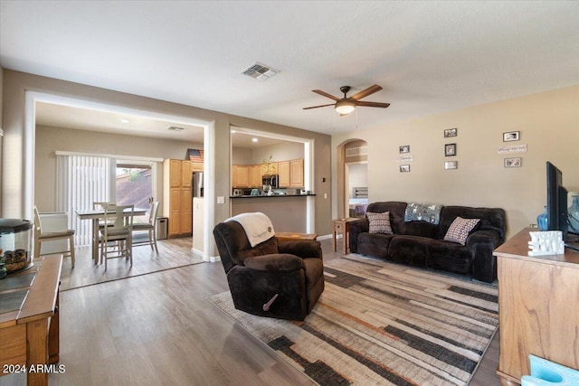 living room with light hardwood / wood-style flooring and ceiling fan