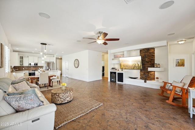 living room featuring ceiling fan, recessed lighting, and baseboards