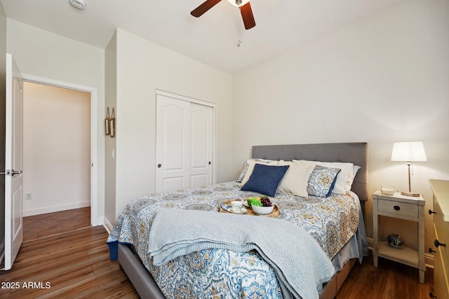 bedroom featuring a ceiling fan, a closet, baseboards, and wood finished floors