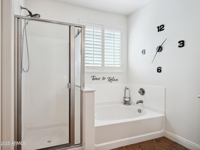 full bathroom featuring tile patterned floors, a stall shower, a garden tub, and baseboards