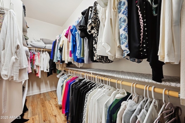 walk in closet with light wood-style floors