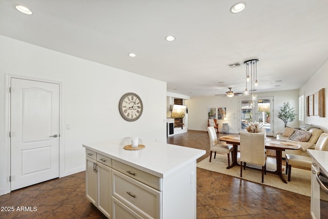 kitchen featuring visible vents, a kitchen island, open floor plan, light countertops, and recessed lighting